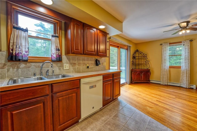 kitchen with white dishwasher, sink, light hardwood / wood-style flooring, ceiling fan, and tasteful backsplash