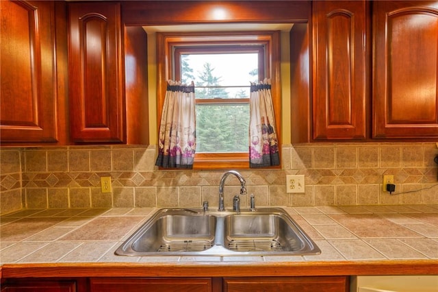 kitchen featuring tile countertops, decorative backsplash, and sink