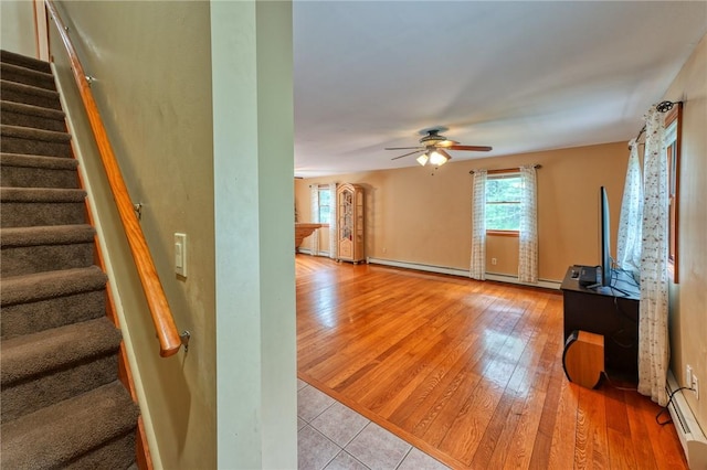 interior space featuring wood-type flooring, a baseboard radiator, and ceiling fan