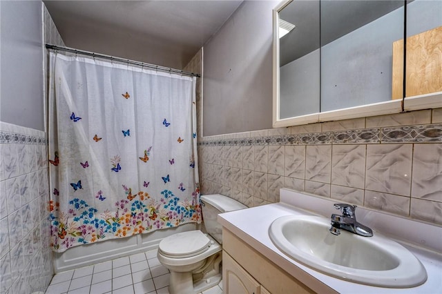 full bathroom featuring shower / bathtub combination with curtain, tile patterned flooring, toilet, vanity, and tile walls