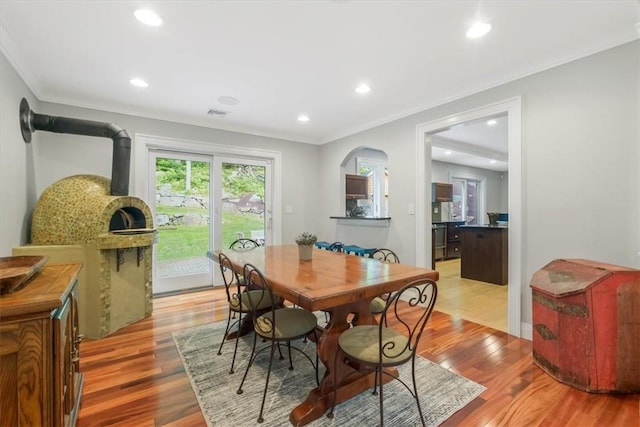 dining space with light wood-type flooring and ornamental molding