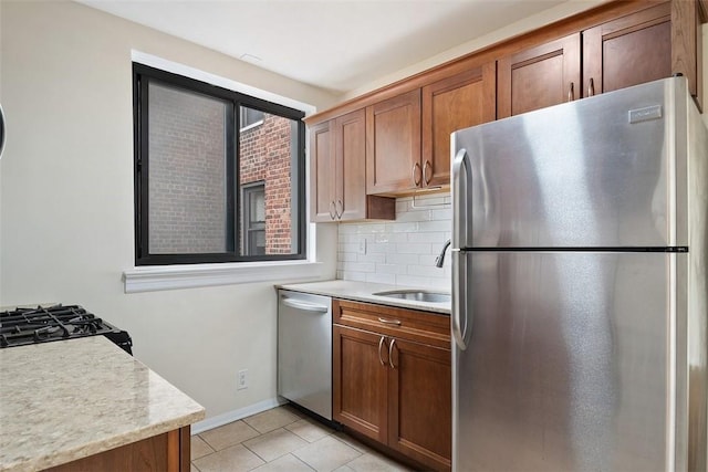 kitchen with decorative backsplash, sink, light tile patterned floors, and stainless steel appliances