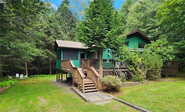 back of house featuring a lawn and a wooden deck