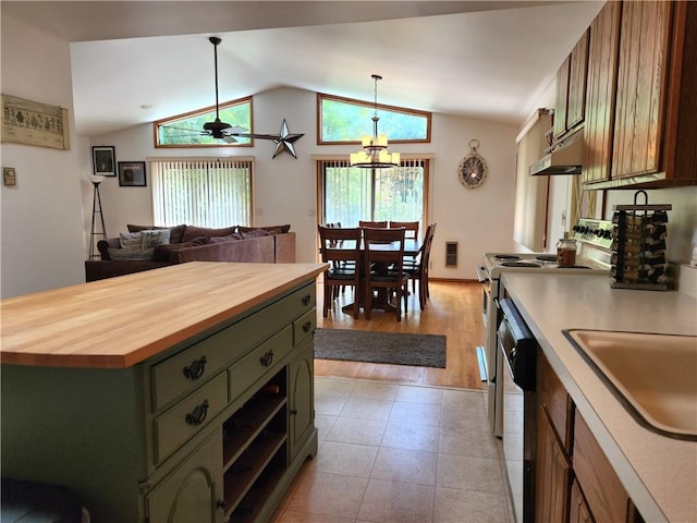 kitchen with a wealth of natural light, vaulted ceiling, hanging light fixtures, and butcher block counters