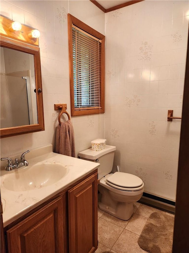 bathroom featuring baseboard heating, tile patterned floors, toilet, vanity, and tile walls