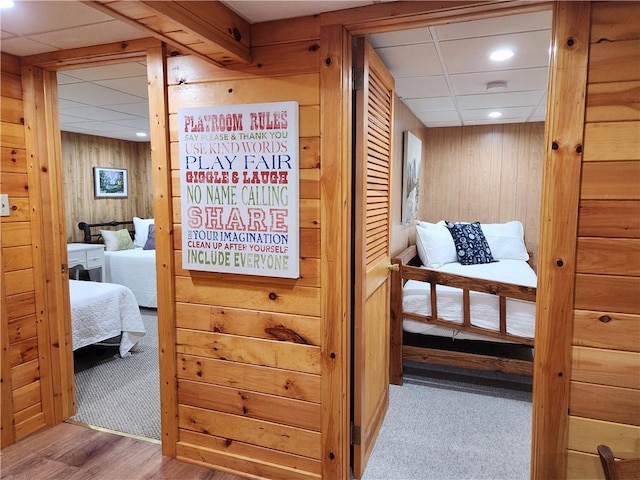 hallway featuring light hardwood / wood-style flooring and wooden walls