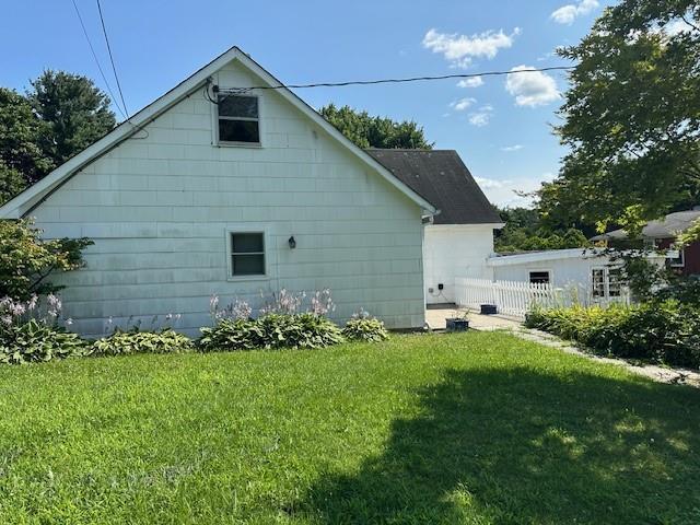 view of side of home featuring a yard and fence