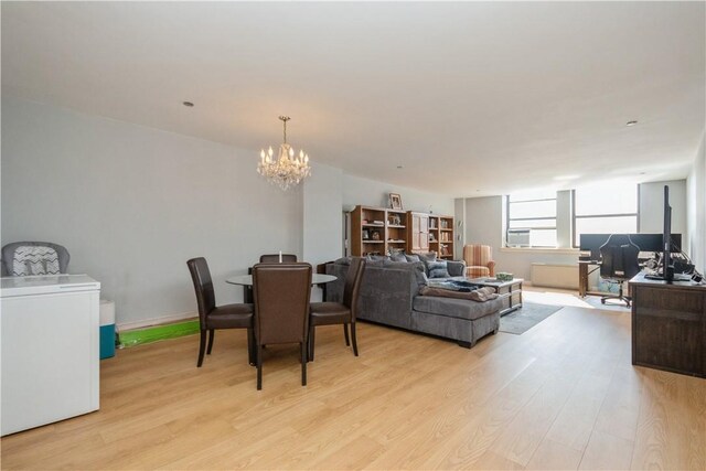 dining area with an inviting chandelier, light wood-style flooring, and baseboards