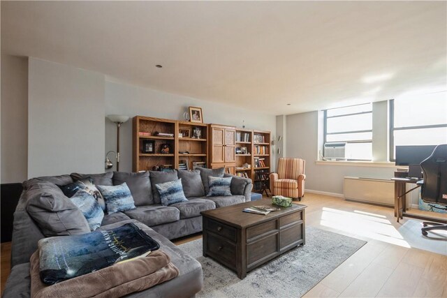 living area featuring cooling unit and light wood finished floors