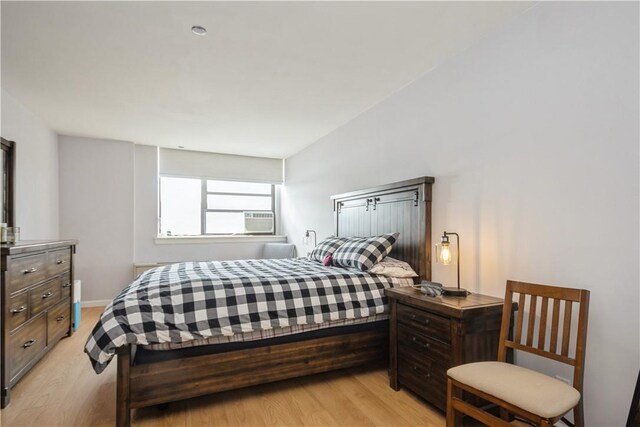 bedroom featuring light wood finished floors and baseboards