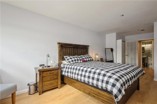 bedroom with light wood-style flooring and baseboards