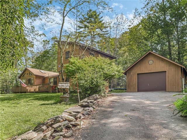 view of front of home with a garage, a trampoline, an outbuilding, and a front lawn