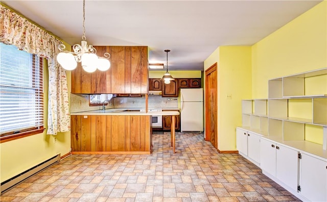 kitchen featuring white appliances, backsplash, hanging light fixtures, a baseboard radiator, and kitchen peninsula