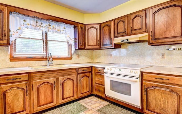 kitchen with backsplash, electric range, and sink