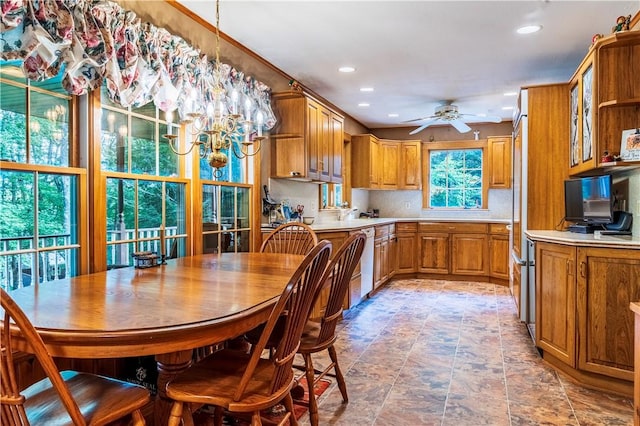 kitchen with dishwasher, decorative backsplash, and ceiling fan with notable chandelier