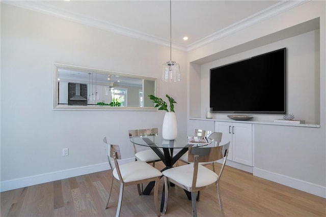 dining room featuring light hardwood / wood-style floors and crown molding