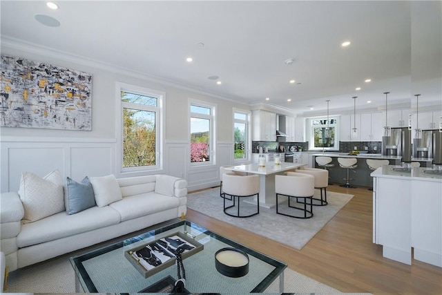 living room featuring light wood-type flooring and crown molding