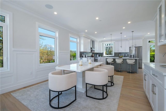 dining area with light hardwood / wood-style floors and ornamental molding