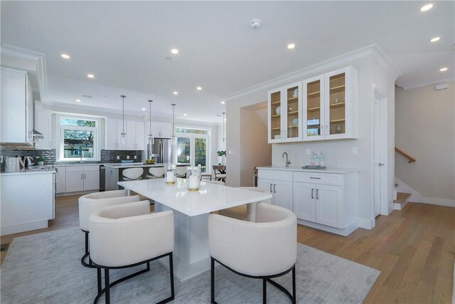 kitchen with white cabinetry, a kitchen island, and a healthy amount of sunlight