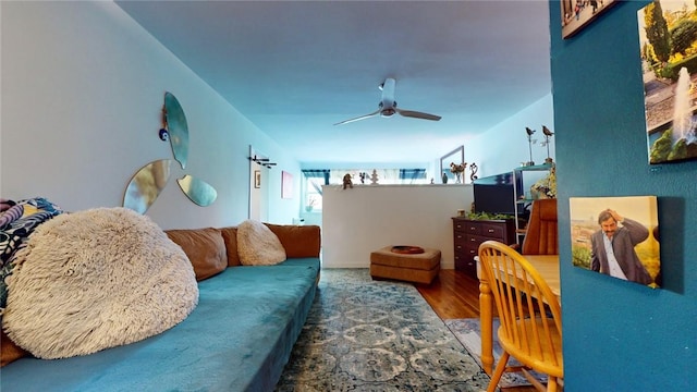 living room featuring ceiling fan and dark hardwood / wood-style floors