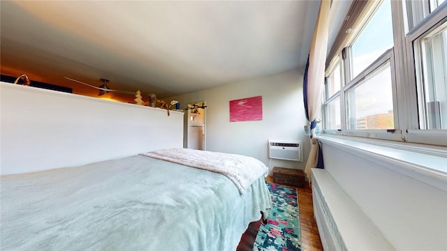 bedroom featuring a wall mounted air conditioner, hardwood / wood-style flooring, and lofted ceiling