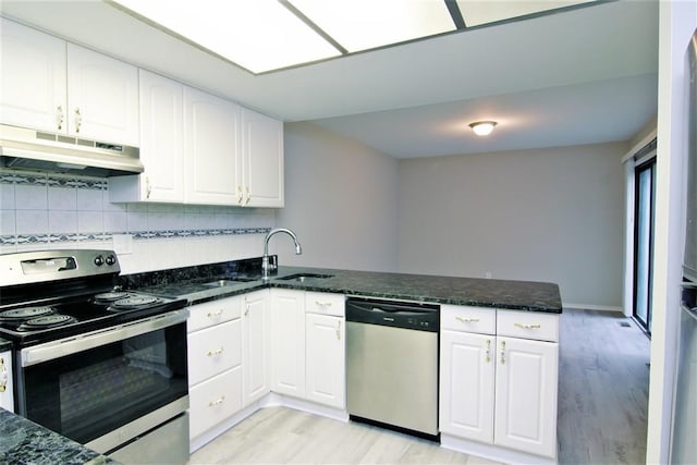 kitchen with kitchen peninsula, appliances with stainless steel finishes, light wood-type flooring, and white cabinetry