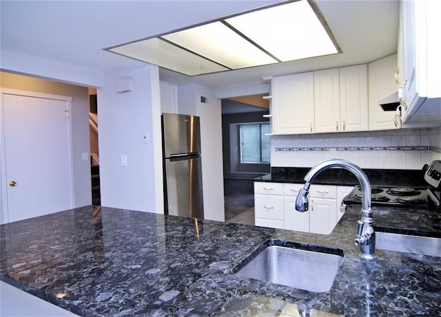 kitchen with backsplash, dark stone counters, stainless steel appliances, sink, and white cabinets