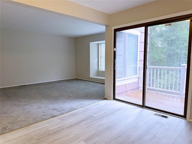 unfurnished room featuring a healthy amount of sunlight and light wood-type flooring