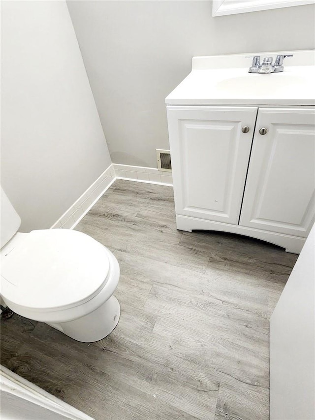 bathroom featuring hardwood / wood-style floors, vanity, and toilet