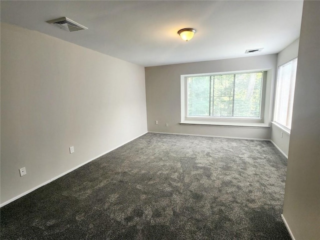 unfurnished room with dark colored carpet