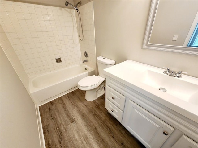 full bathroom featuring toilet, hardwood / wood-style floors, vanity, and tiled shower / bath