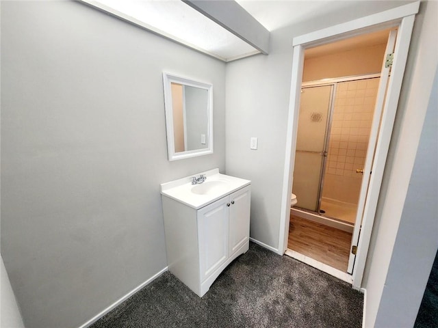 bathroom with vanity, toilet, and a shower with door