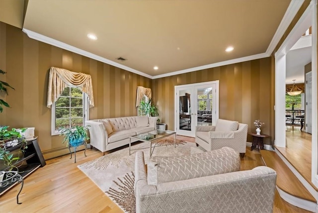 living room with wood-type flooring, french doors, plenty of natural light, and crown molding