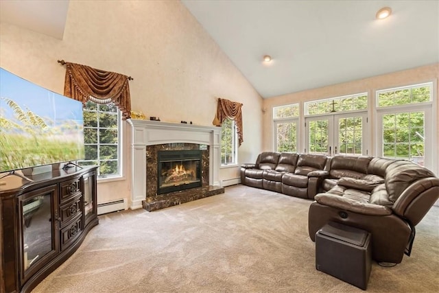 carpeted living room featuring a fireplace, a healthy amount of sunlight, and a baseboard heating unit