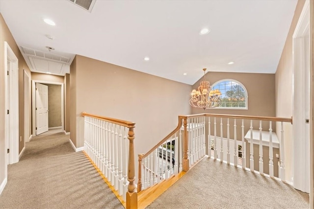 hallway featuring a chandelier, light colored carpet, and vaulted ceiling