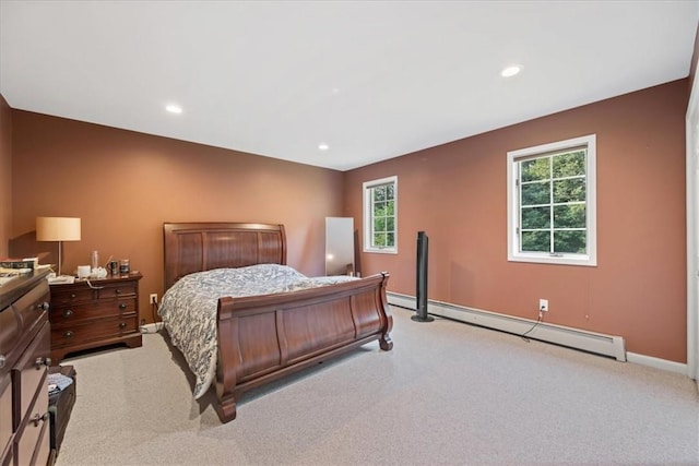 bedroom featuring light colored carpet, multiple windows, and a baseboard heating unit