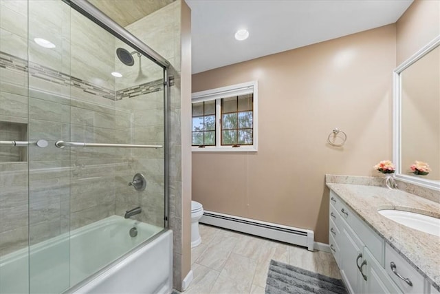 full bathroom featuring vanity, toilet, a baseboard heating unit, and enclosed tub / shower combo