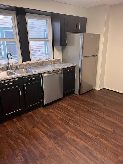 kitchen with a healthy amount of sunlight, dark hardwood / wood-style flooring, stainless steel appliances, and sink