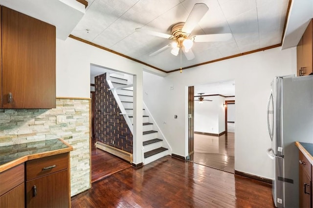 kitchen featuring stainless steel refrigerator, baseboard heating, tasteful backsplash, dark hardwood / wood-style flooring, and ornamental molding