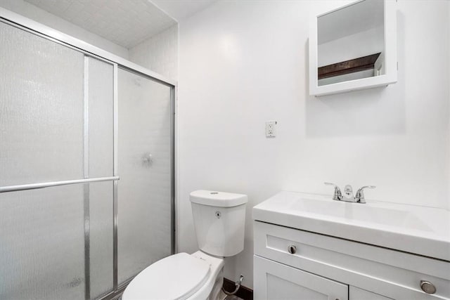 bathroom featuring vanity, toilet, and a shower with shower door