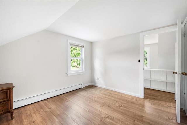 additional living space featuring light wood-type flooring, baseboard heating, and lofted ceiling