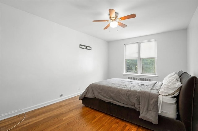 bedroom featuring wood-type flooring, ceiling fan, and radiator