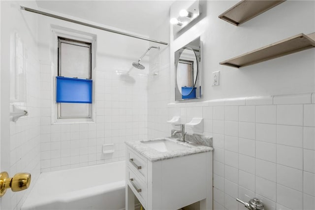 bathroom featuring vanity, tile walls, and tiled shower / bath