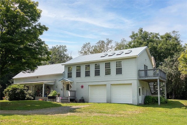 view of front of property with a garage, a deck, and a front yard