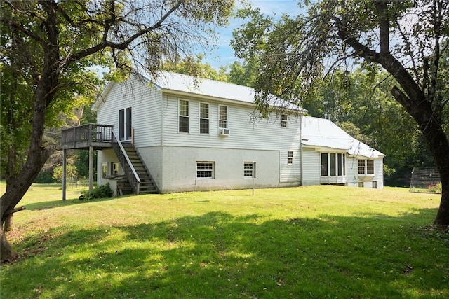 rear view of property with a wooden deck and a yard