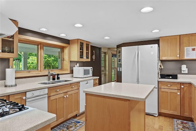 kitchen featuring light stone countertops, sink, a center island, light hardwood / wood-style floors, and white appliances