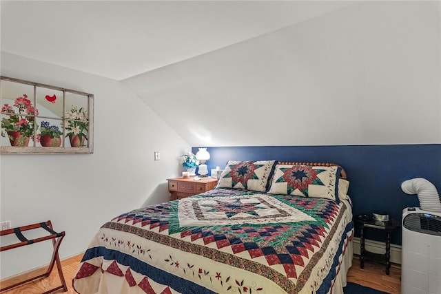 bedroom with wood-type flooring and vaulted ceiling