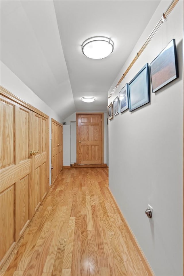 corridor featuring vaulted ceiling and light wood-type flooring