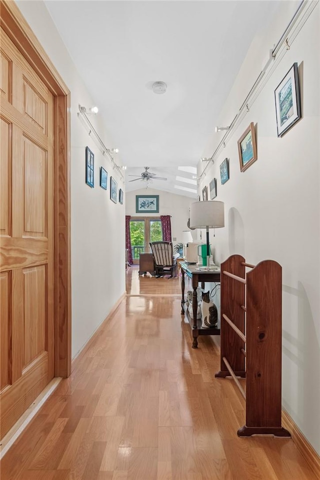 hallway featuring light hardwood / wood-style floors and vaulted ceiling