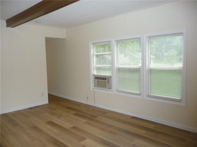 unfurnished room featuring beamed ceiling, cooling unit, and light wood-type flooring